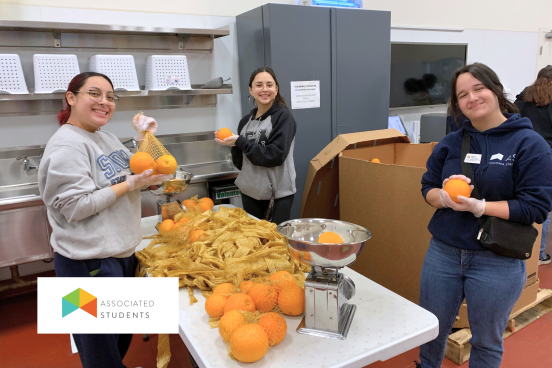 Students weighing produce in a commercial kitchen.