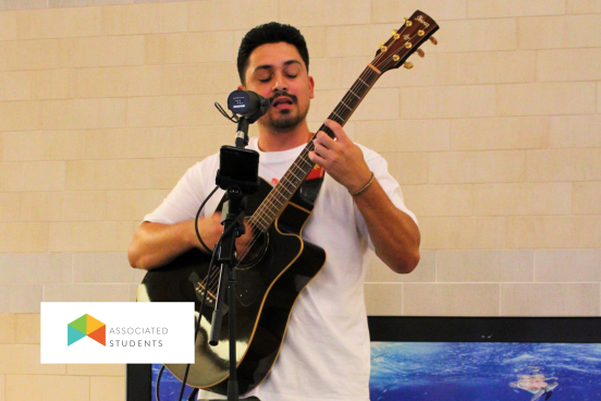 Man playing a guitar and singing into a mic.