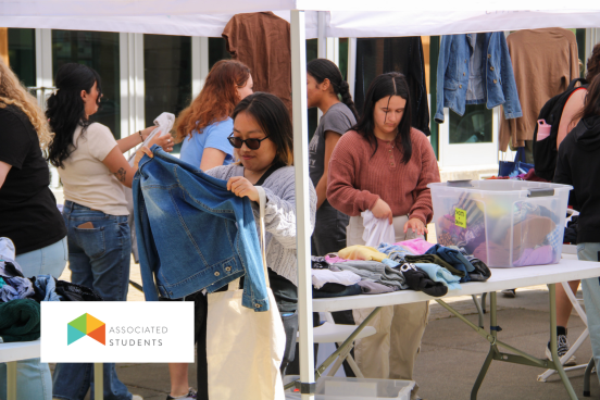Students picking out clothes from an AS pop up tent.