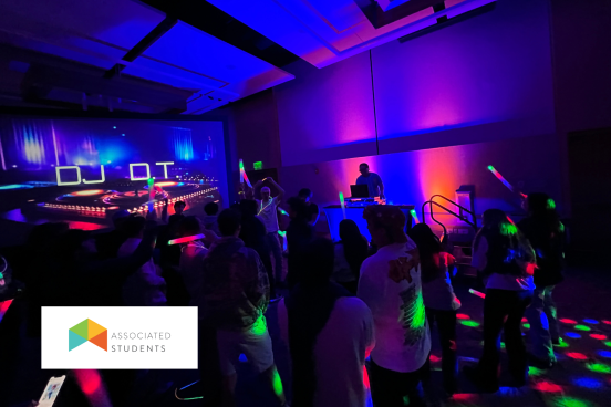Students dancing with LED lights with a DJ playing music.