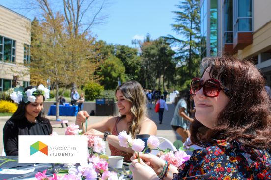 Students crafting with flowers at a table in Seawolf Plaza.
