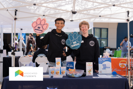 Two students tabling with meal kit supplies giveaways