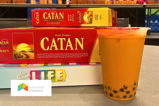 Board Games stacked next to a Boba tea drink.