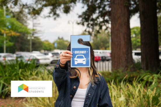Student holding out an oversized parking permit that says "Giveaway"