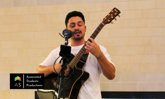 Man singing while playing guitar.
