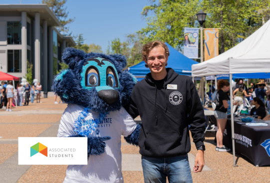 Student posing for a photo with Lobo