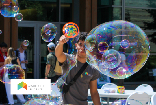 Student using a bubble wand in Seawolf Plaza