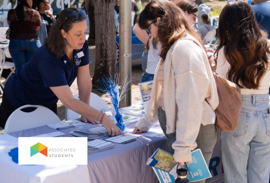 SSU staff explaining a flier to a student at a tabling fair