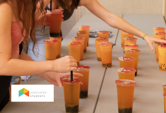 Students picking up boba drinks off a table in the ballrooms.