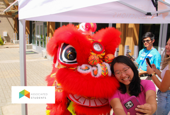 Student posing for a photo with a Lion Dance performer.