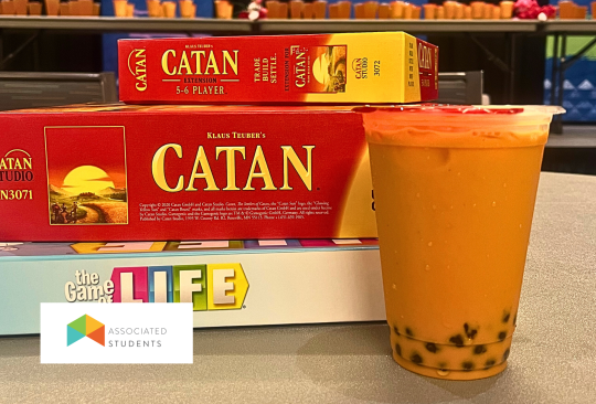 Board Games stacked next to a Boba tea drink.