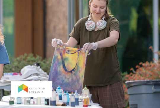 Person tie-dying a tote bag.